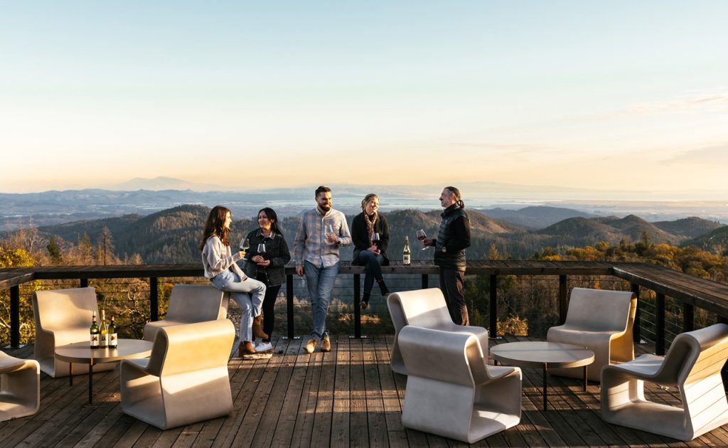 Mayacamas Vineyards guests talking and tasting wine on deck. 