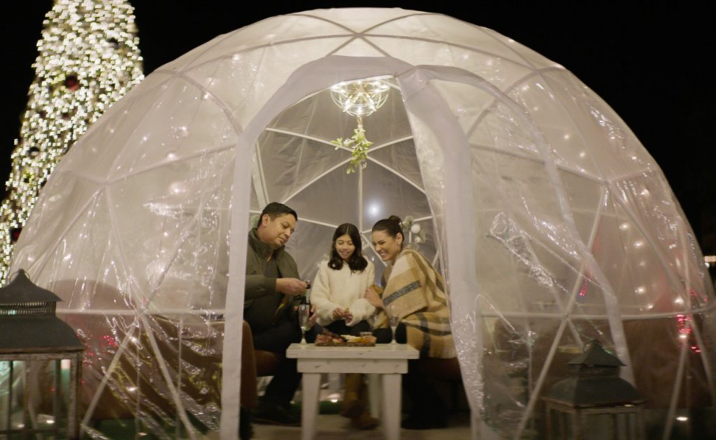 Guests enjoy food and drinks inside Merry Meritage Igloo at Meritage Resort & Spa in Napa.