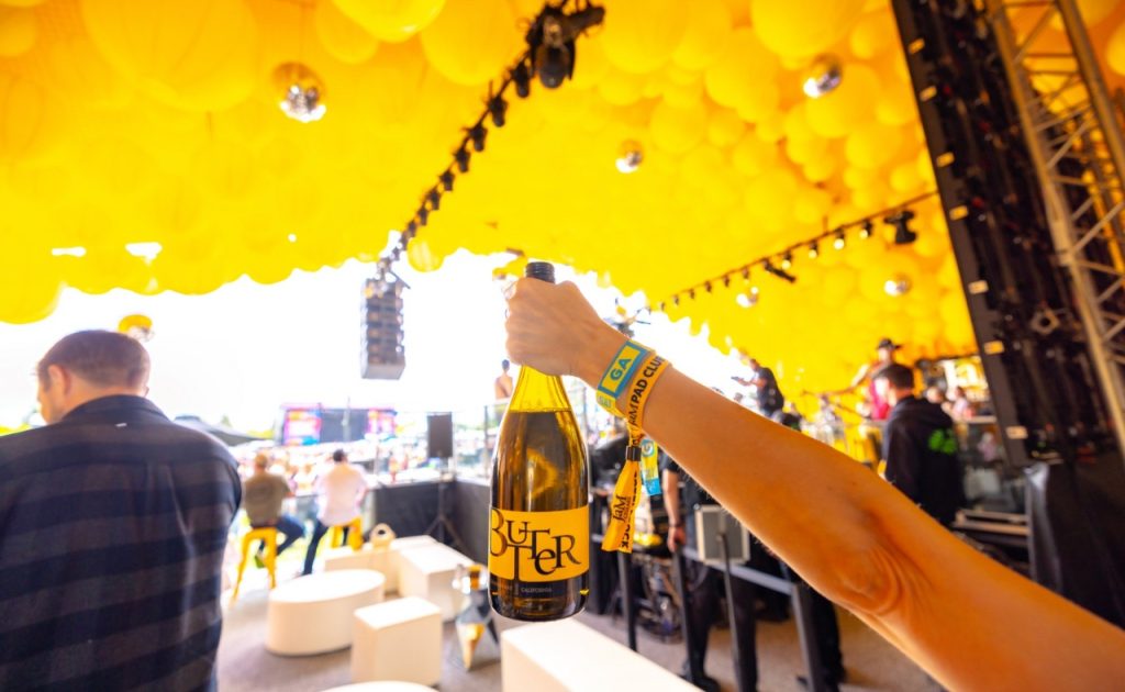 BottleRock Napa Valley tent with guest holding wine bottle. 