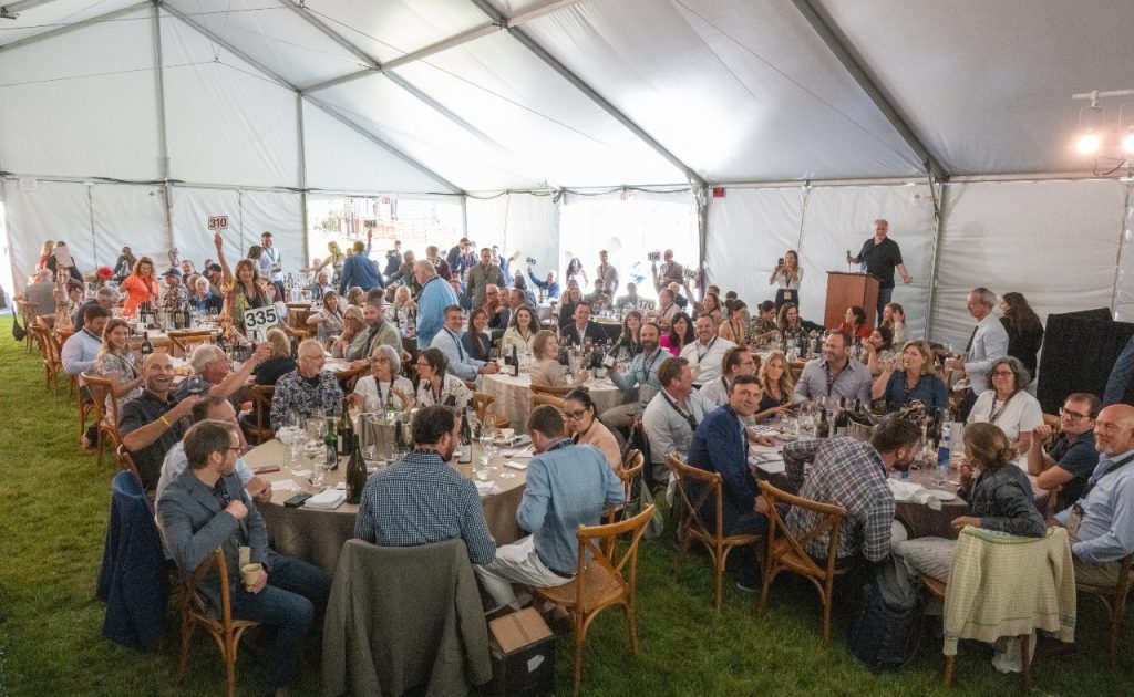 Guests eating, drinking and bidding under the tent at Sonoma County Barrel Auction.
