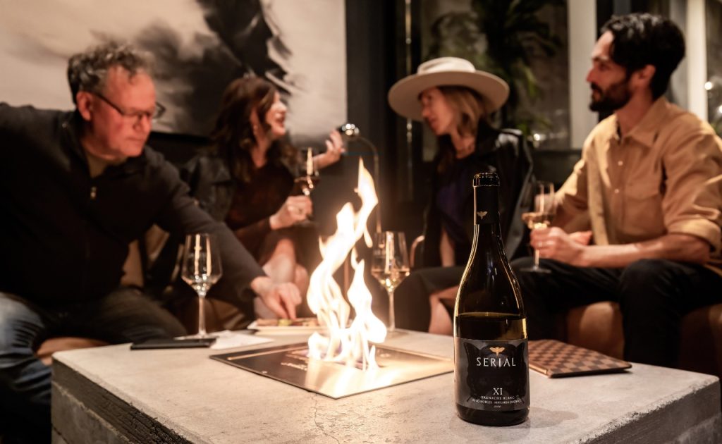 Serial Wines tasting lounge fire pit with guests gathered around drinking wine.