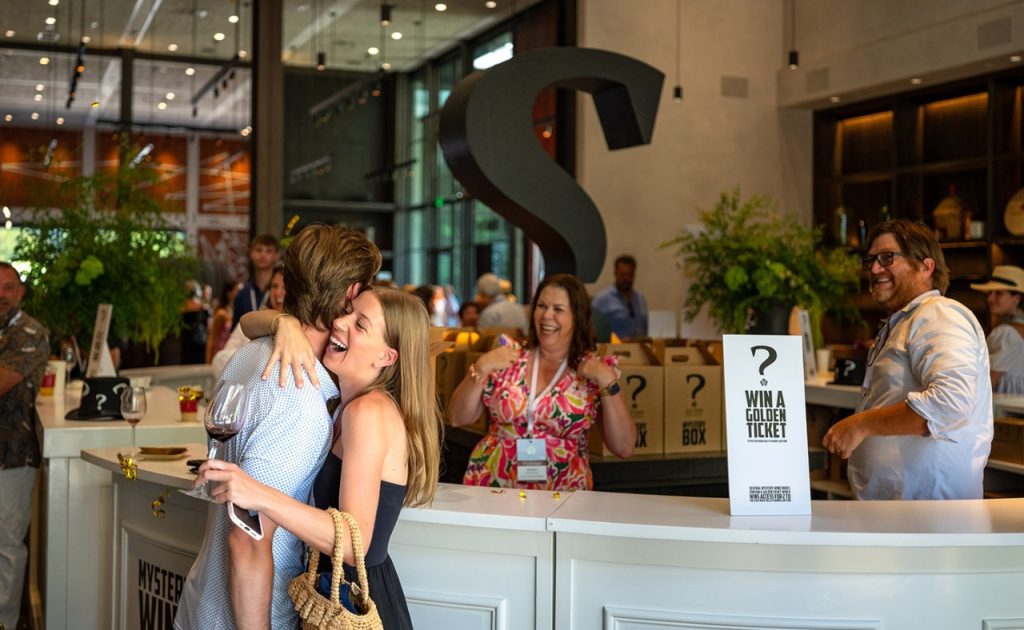 Auction Napa Valley guests hugging  at Louis M. Martini Winery.