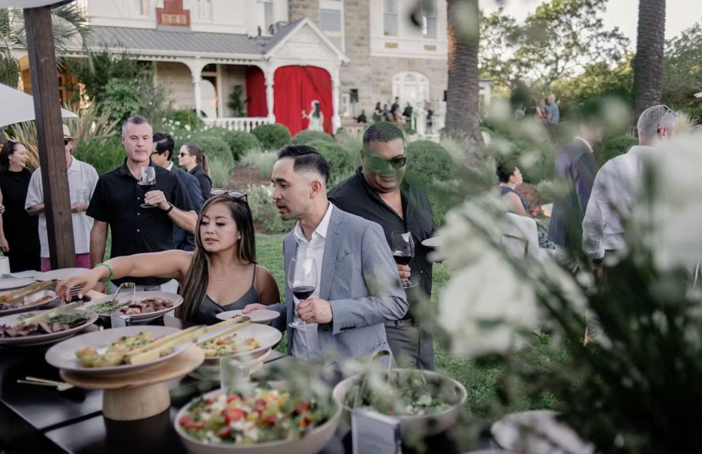 Guests reaching for food during Summer Soirée event at Spring Mountain Vineyard.