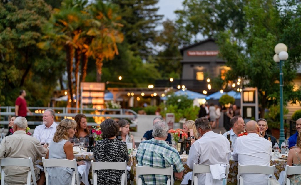 Guests at Calistoga Harvest Table with town in the background.