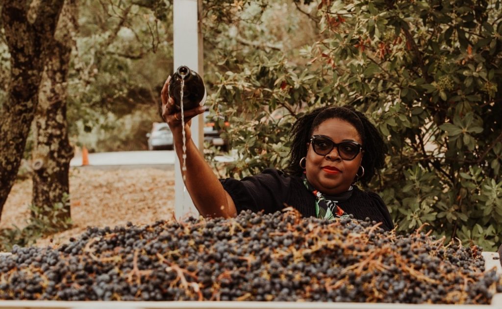 Pouring sparkling wine on the first grapes of the vintage.
