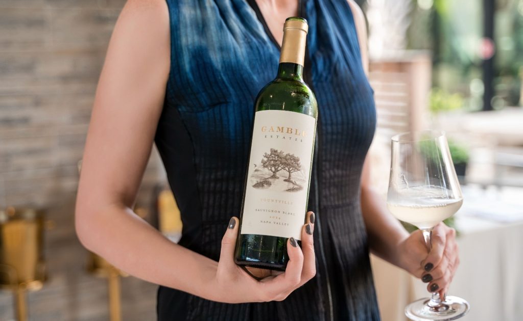 Woman holding Gamble Estates wine.